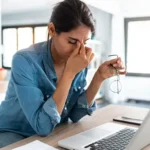 stressed business woman working from home on laptop looking worried tired and overwhelmed